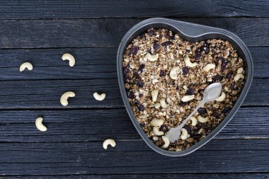 Bir fırın tepsisine kaju granola. Siyah ahşap masa