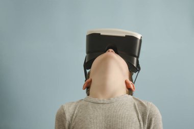 Sanal gerçeklik gözlüklü çocuk. Arama yapar. Mavi arka plan