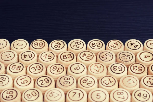 Wooden kegs of lotto on the edge of the black table. Space for text