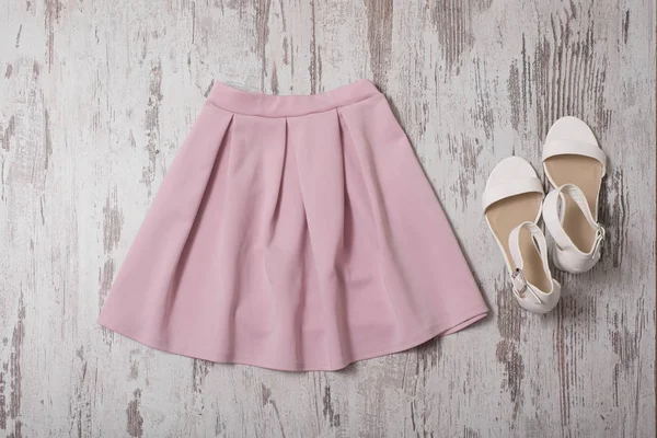 Moda kavramı. Pembe etek ve beyaz ayakkabı. Üstten görünüm