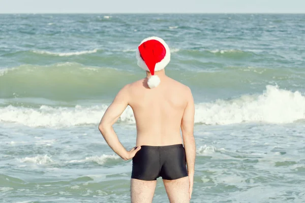 Człowiek Santa Hat Stojąc Plaży Widok Tyłu — Zdjęcie stockowe