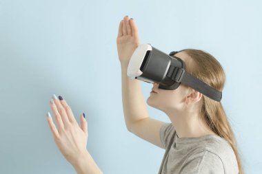 Sanal gerçeklik gözlüklü yuong kadın. Mavi arka plan