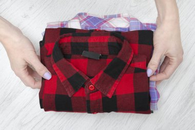 Yeşil, kırmızı ve lavanta ekose gömlekler kadın elinde. Moda kavramı