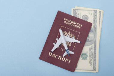 Uçak bir Rus pasaportu kapağında. Dolar. Seyahat kavramı. Mavi arka plan