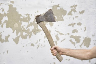 Eski paslı ax uygulamasında elini eski püskü duvara karşı.