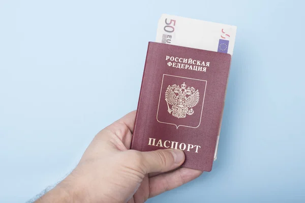 Paszport Rosyjski Międzynarodowych Euro Ręce Mężczyzny Niebieskie Tło — Zdjęcie stockowe