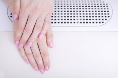 Yumuşak pembe manikür. Manikür salonda eller