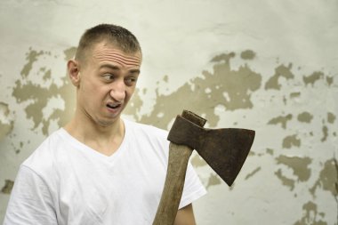 Eski püskü bir wal zemin karşı elinde bir balta ile kızgın adam