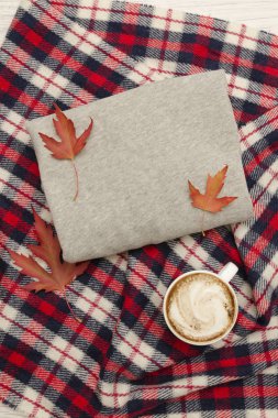 Gri kazak, ekose ve kahve kupa. Sonbahar yaprakları. Moda kavramı