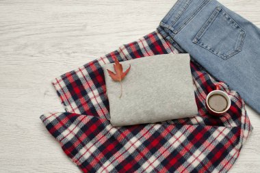 Gri kazak, kot pantolon, ekose ve kahve kupa. Sonbahar yaprakları. Moda kavramı