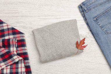 Gri kazak, kot, eşarp ve sonbahar yaprakları. Moda kavramı