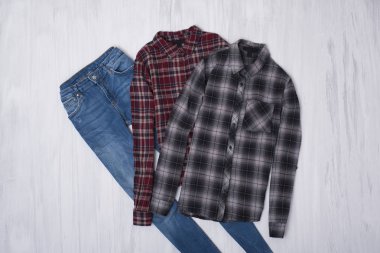 Kareli gömlek ve ahşap arka plan üzerinde kot pantolon. Moda kavramı