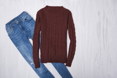 Örme kazak ve ahşap arka plan üzerinde kot pantolon. Moda kavramı