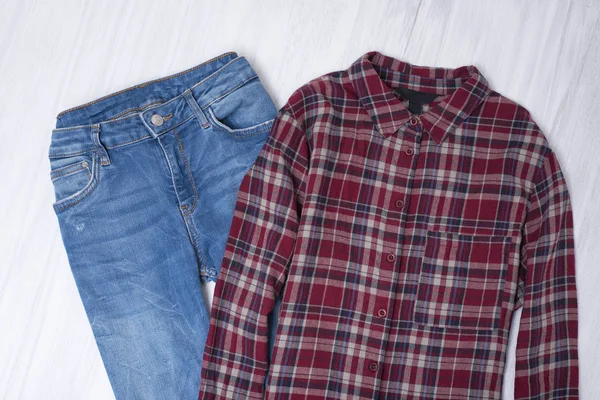 Blå Jeans Och Röd Rutig Skjorta Trä Bakgrund Fashionabla Koncept — Stockfoto