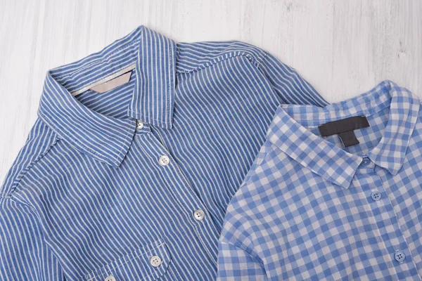 Blue striped and checkered shirt on wooden background. Fashionable concept