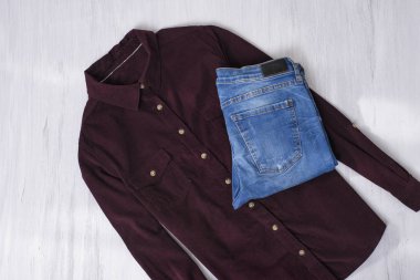 Bordo kadife gömlek ve mavi jeans ahşap arka plan üzerinde. Moda kavramı