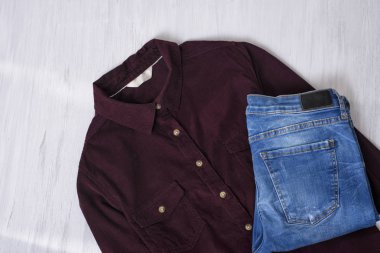 Bordo kadife gömlek ve mavi jeans ahşap arka plan üzerinde. Moda kavramı