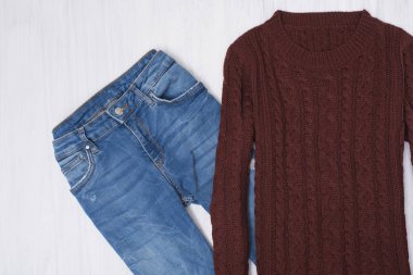 Örme kazak ve ahşap arka plan üzerinde kot pantolon. Moda kavramı