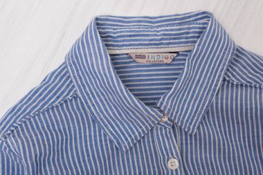 Kharkov, Ukrayna - 1 Ekim 2018: ahşap zemin üzerine mavi çizgili gömlek yaka. Indigo koleksiyonu