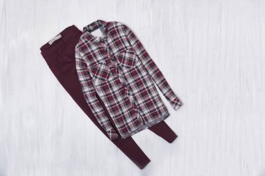 Kareli gömlek ve ahşap arka plan üzerinde Bordo kot pantolon. Moda kavramı