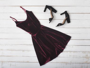 Bordo kadife elbise ve ahşap arka plan üzerinde ayakkabı. Moda kavramı