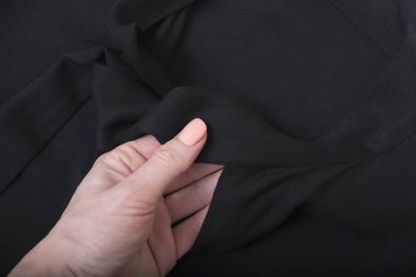 Kadın elinde siyah bluz ayrıntıları. Yakın çekim. Moda kavramı