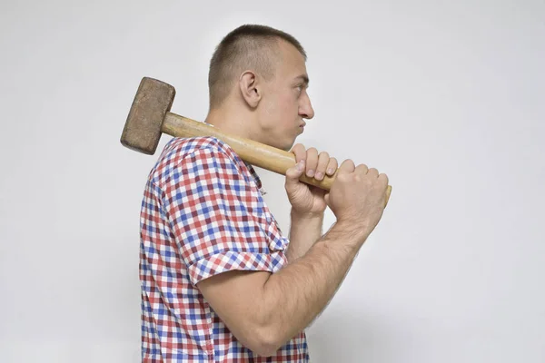 Man with a sledgehammer on a white background. Work concept