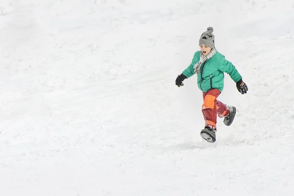 Fiú Zöld Kabát Vörös Nadrágot Fut Hóban Téli Napon — Stock Fotó