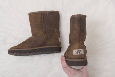 Kharkov, Ukrayna - 07 Kasım 2018: kış kahverengi botlar Ugg kadın elinde. Moda kavramı