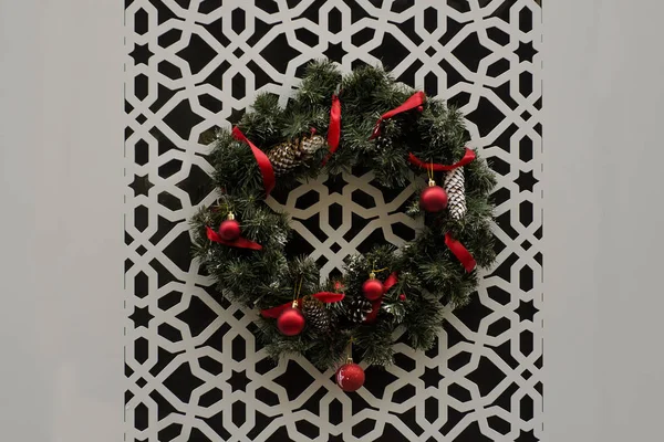 Різдвяний Вінок Червоними Стрічками Висять Стіні Різьбленим Орнаментом — стокове фото