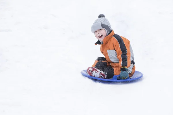 Felice Ridendo Piccolo Ragazzo Scivola Giù Collina Sul Disco Neve — Foto Stock