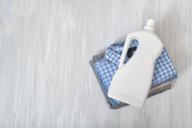 Katlanmış giysiler ve deterjan şişe yığını. Üstten görünüm