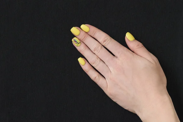 Vrouwelijke Hand Met Gele Manicure Zwarte Stof Close — Stockfoto