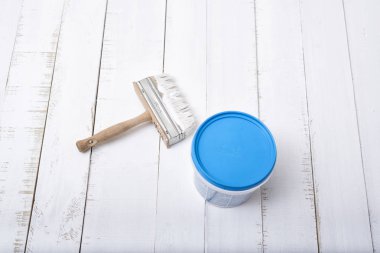 Ev yenileme kavramı. Arka plan beyaz, eski püskü ahşap plakalar üzerinde fırça ve boya bir kova