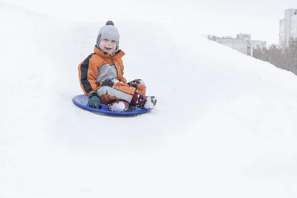 Feliz Niño Riendo Desliza Por Colina Platillo Nieve Concepto Estacional —  Fotos de Stock