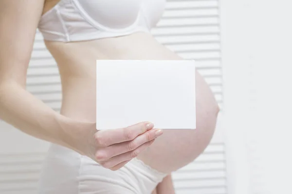 Mujer Embarazada Sostiene Una Sábana Blanca Blanco Vientre Fondo Concepto — Foto de Stock