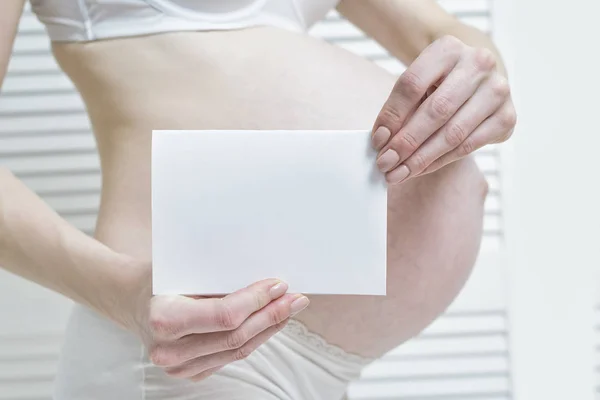 Mujer Embarazada Sostiene Una Sábana Blanca Blanco Vientre Fondo Concepto — Foto de Stock