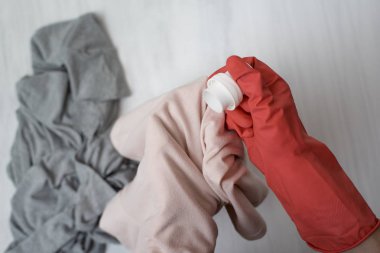 Elinde eldiven sıvı yıkama kıyafetlere dökülen. Yakın çekim