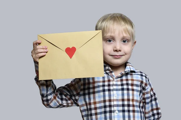 Petit Garçon Blond Tient Une Enveloppe Avec Coeur Sur Fond — Photo