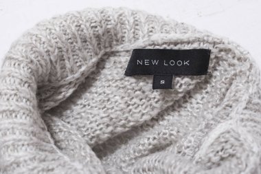 Kharkov, Ukrayna - 17 Ocak 2019: Etiketi ile örme Gri süveter Yakası kelime yeni bak. Giysi ve aksesuarları. Yakın çekim.