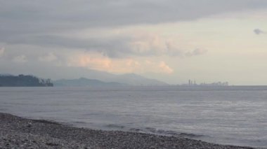 Gökdelenler ve denizin karşısında bankadan kenti. Akşam güneş battıktan sonra. Batum, Gürcistan