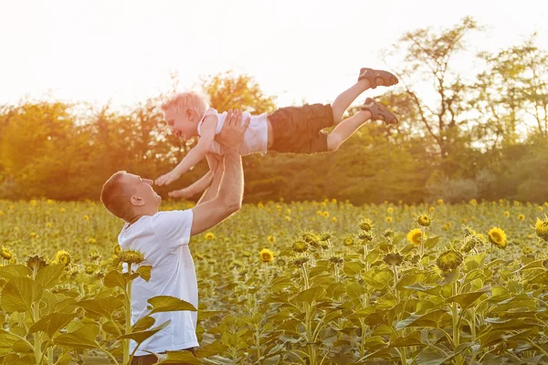 Babası oğlunun bir yeşil ayçiçekleri alanı gökyüzü kadar atar
