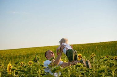 Babası oğlunun bir yeşil ayçiçekleri alanı gökyüzü kadar atar.