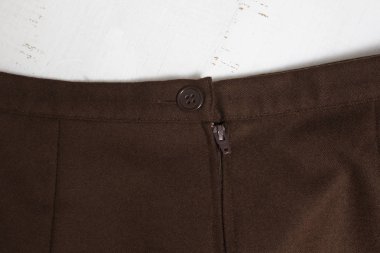 Moda giysiler. Kahverengi mini etek, düğme ve fermuar parçası