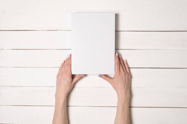 Beyaz dikdörtgen kutu kadın elinde. Üstten Görünüm. Arka plan beyaz masaya