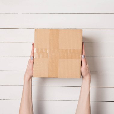 Kadın elinde parsel. Üstten Görünüm. Arka plan beyaz masaya