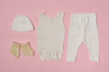 Pembe bir arka plan üzerinde bebek moda kavramı. Cap, gömlek, pantolon ve çorap.