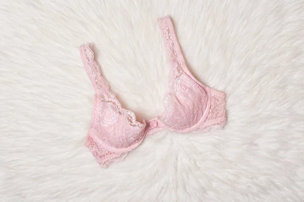 Soutien-gorge en dentelle rose sur fourrure blanche. Pose plate. Concept lingerie mode . — Photo