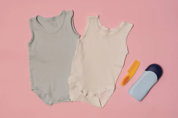 Body de bebé azul y blanco sobre fondo rosa. Accesorios. Concepto de moda —  Fotos de Stock