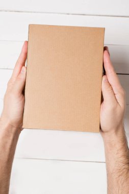Dikdörtgen kutu erkek elinde. Üstten Görünüm. Arka plan beyaz masaya